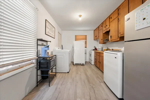 a view of a kitchen with fridge and wooden floor