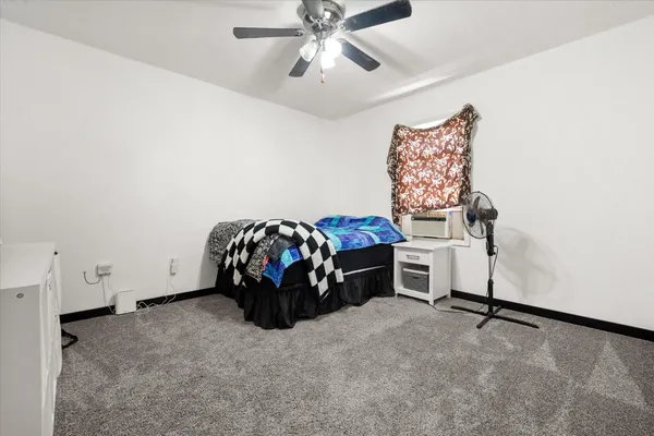 a bed room with a bed and a ceiling fan