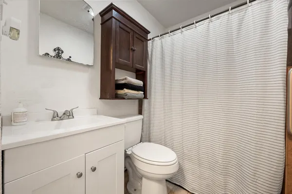 a bathroom with a sink a toilet and shower curtain