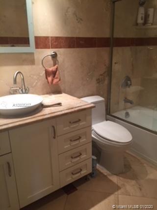 a bathroom with a granite countertop toilet sink and mirror