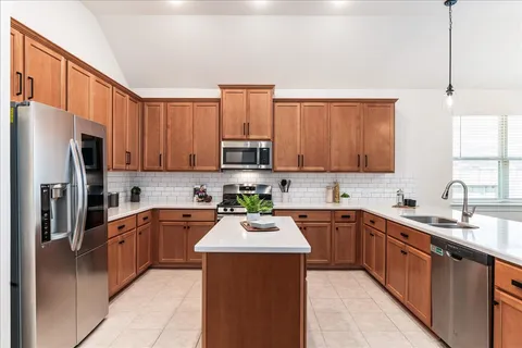 a kitchen with stainless steel appliances granite countertop a refrigerator stove and sink