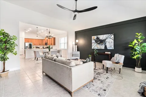 a living room with furniture a flat screen tv and a large window