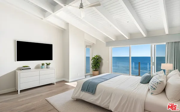 a spacious bedroom with a large bed and a flat screen tv