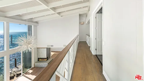 a spacious bedroom with a large bed a flat tv screen and a potted plant