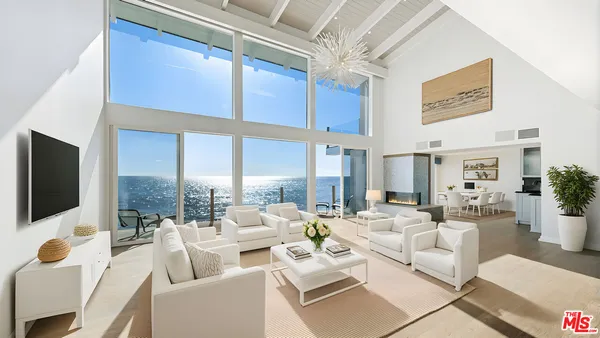 a living room with furniture a flat screen tv and a chandelier