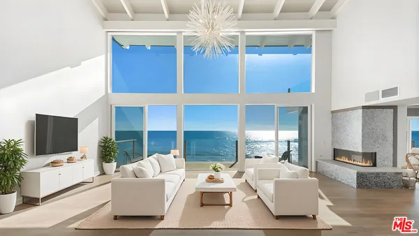 a living room with furniture a flat screen tv and kitchen view
