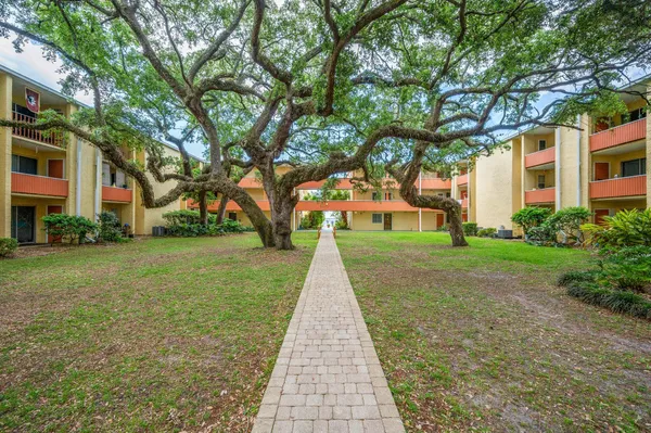 a kitchen with stainless steel appliances kitchen island granite countertop a lot of cabinets and wooden floors