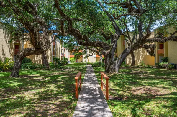 a view of a swimming pool with a yard and plants