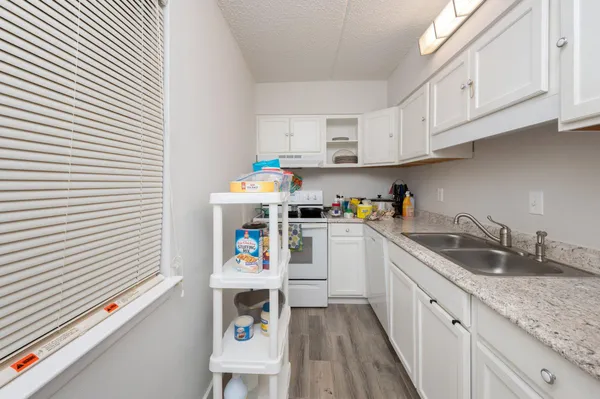 a kitchen with granite countertop white cabinets and white appliances