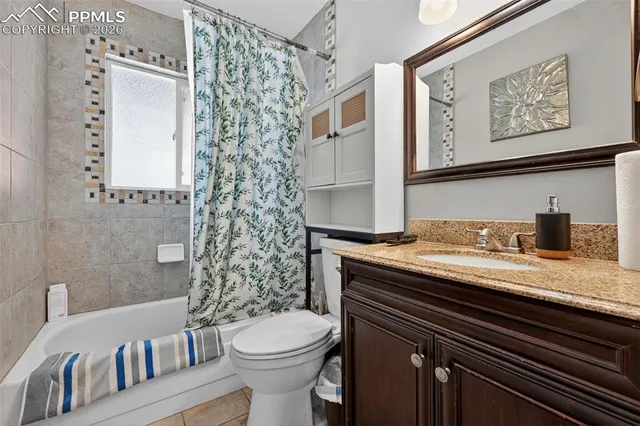 a bathroom with a granite countertop toilet sink and mirror