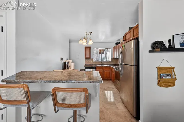 a view of kitchen with furniture and refrigerator