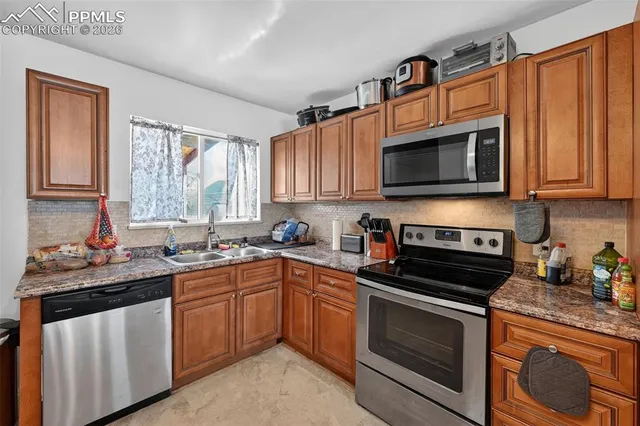 a kitchen with stainless steel appliances a stove sink microwave and cabinets