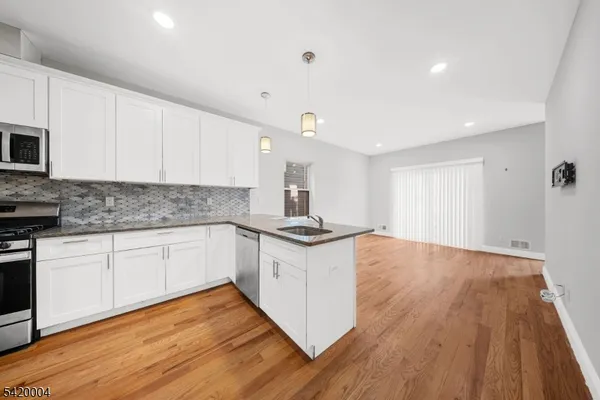 a kitchen with granite countertop a refrigerator and a sink