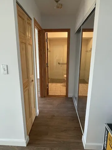 a view of a hallway with wooden floor and staircase
