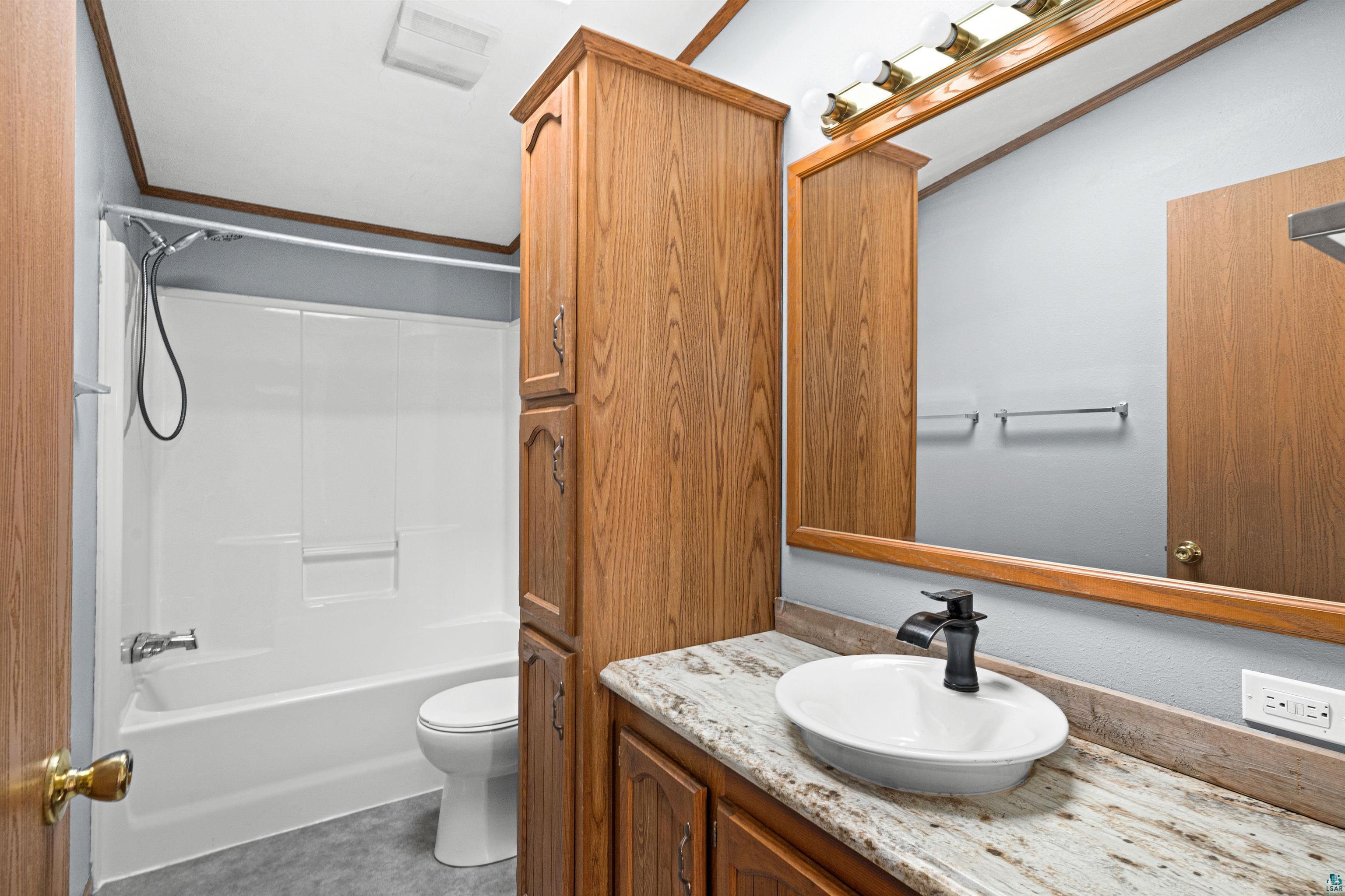 3126 Beyer Road Duluth, MN 55804 - Photo 23 of 23 Bathroom featuring a white tub and shower combination, cabinetry w/countertop with integrated oval basin, black single-handle faucet, and overhead vanity lighting