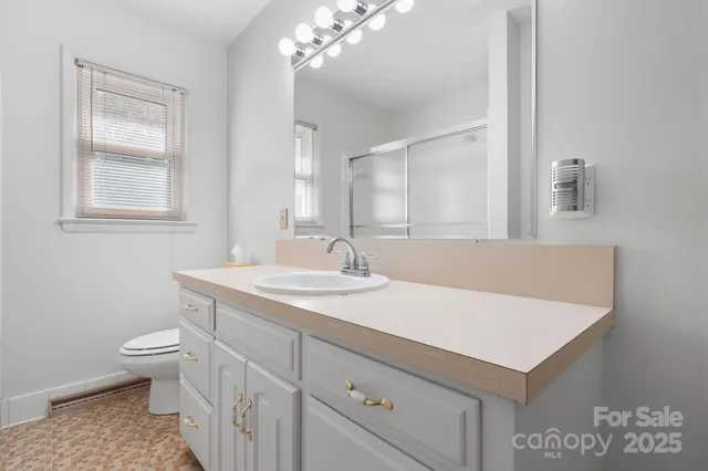 a bathroom with a sink a toilet and a mirror