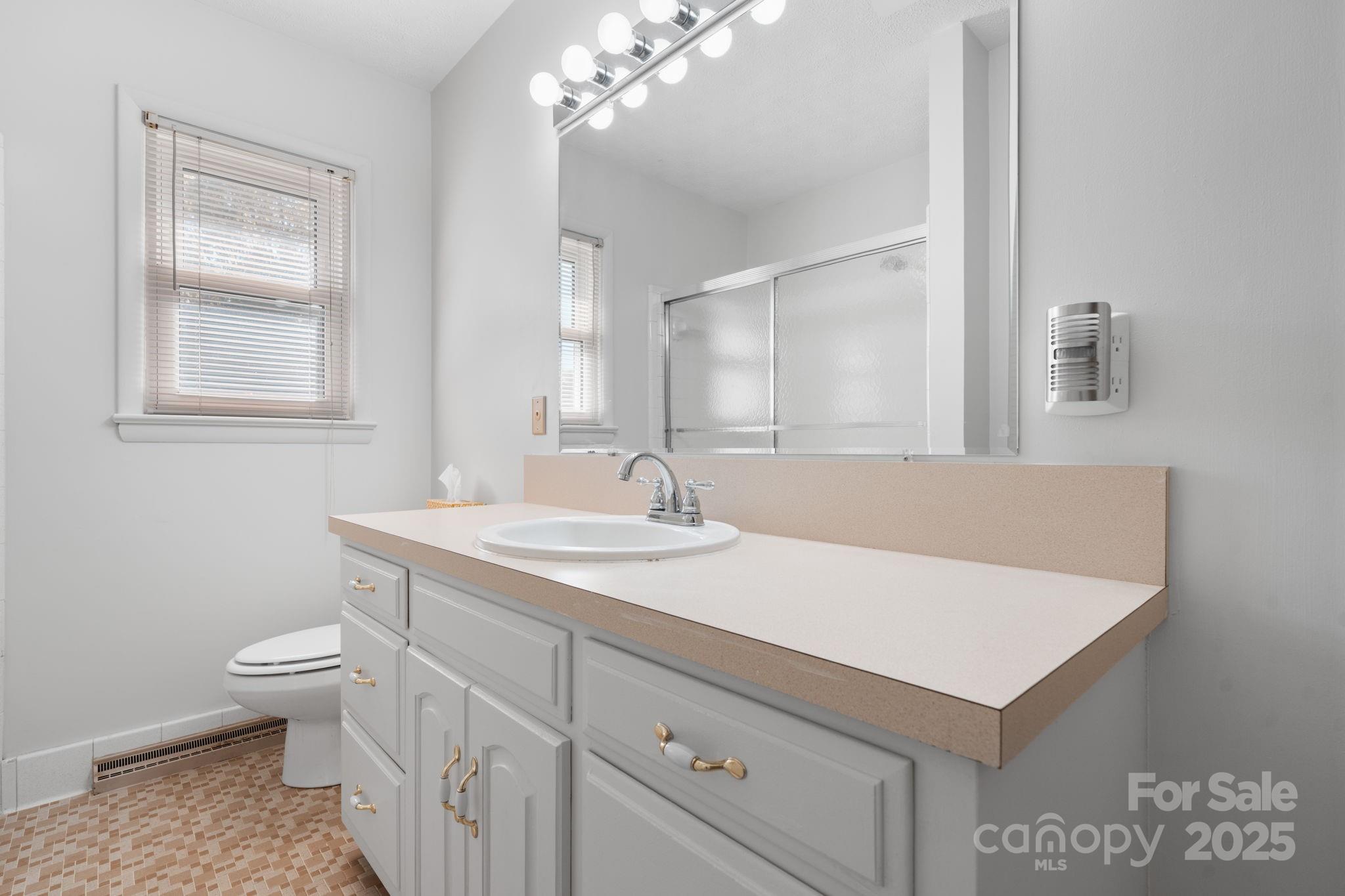 1515 Fairway Acres Road Lenoir, NC 28645 - Photo 12 of 35 a bathroom with a sink a toilet and a mirror