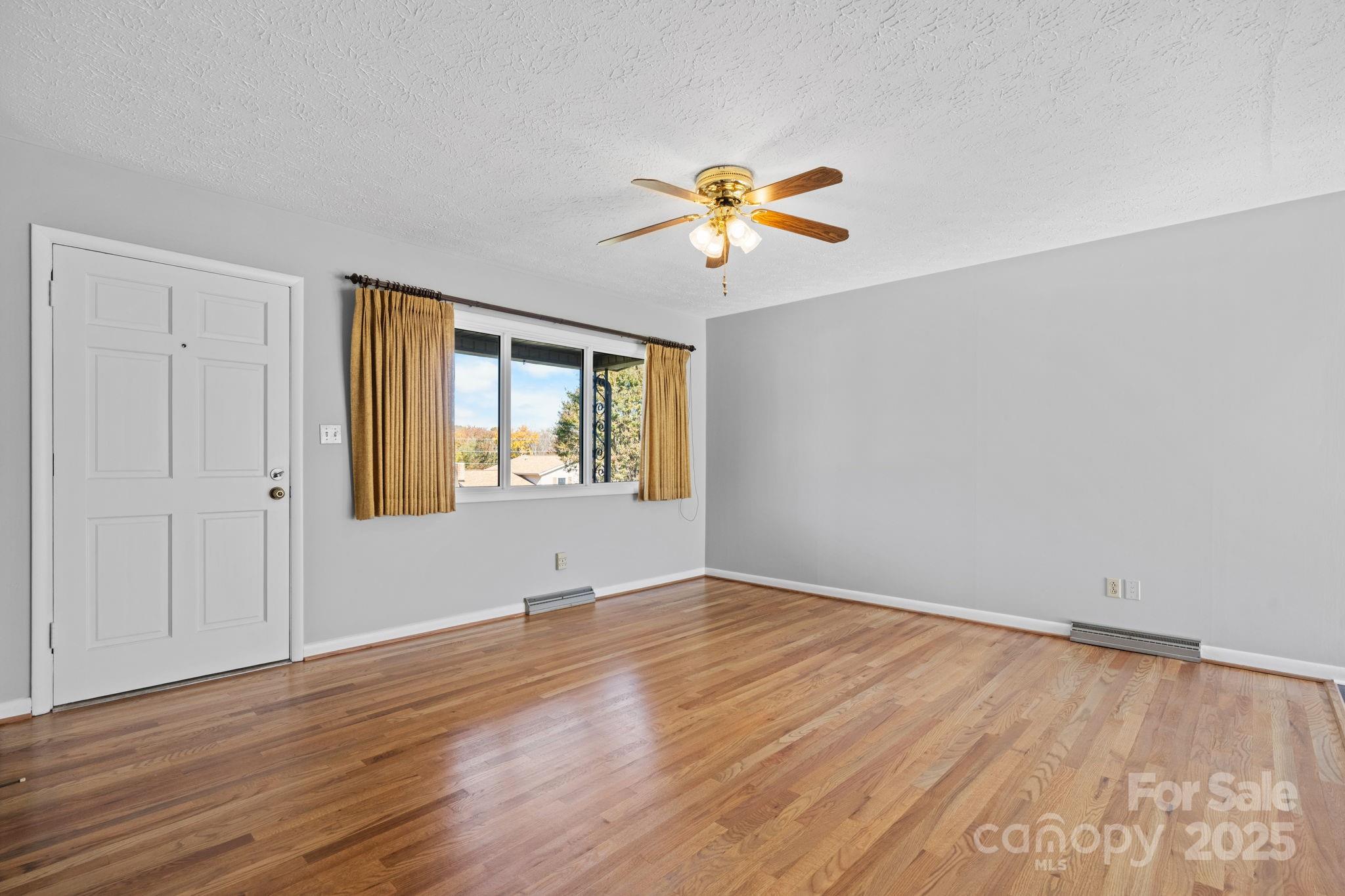 1515 Fairway Acres Road Lenoir, NC 28645 - Photo 5 of 35 a view of an empty room with window and wooden floor
