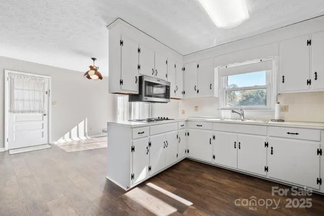 a kitchen with granite countertop white cabinets and white appliances
