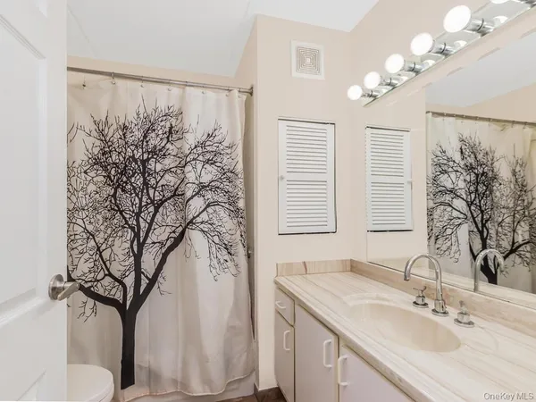 a bathroom with a sink vanity granite and a mirror