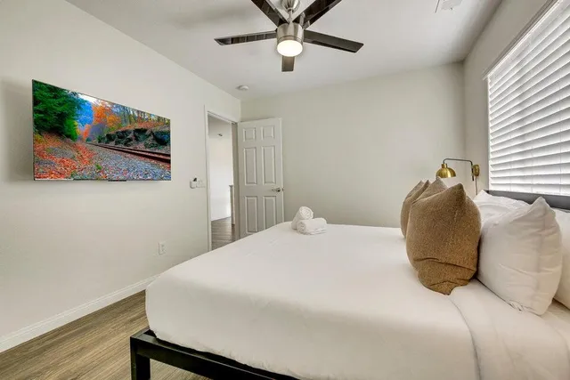 a spacious bedroom with a bed and a chandelier