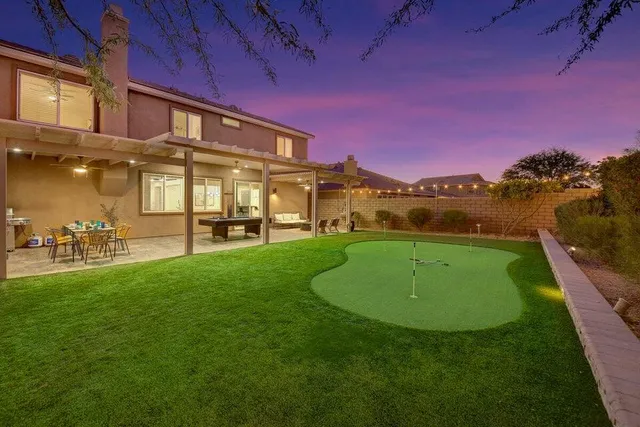a kitchen with stainless steel appliances a table chairs refrigerator and sink