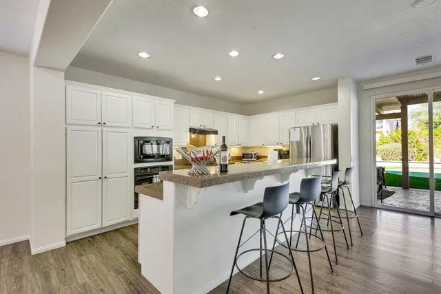 a large kitchen with kitchen island a sink table and chairs