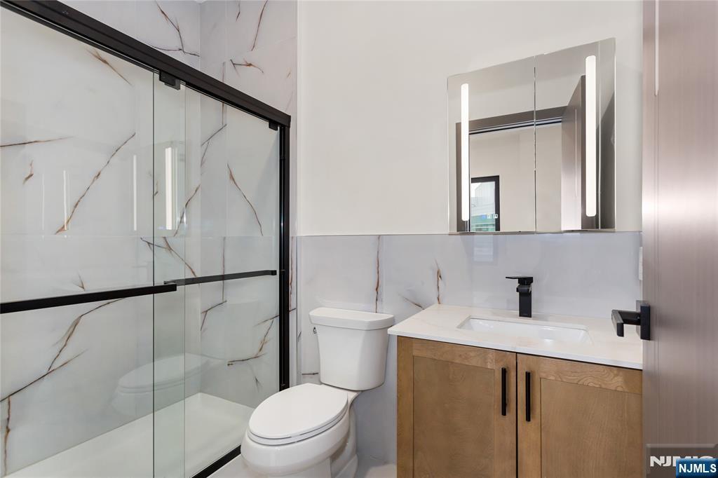 89 Mary Street, Unit 506 Paterson, NJ 07503 - Photo 13 of 15 a bathroom with a toilet sink and shower