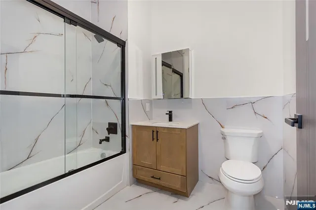 a view of an empty room with a cabinet and mirrors