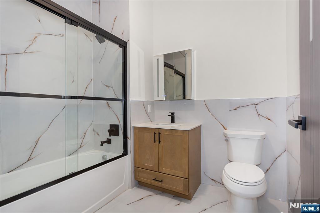 89 Mary Street, Unit 506 Paterson, NJ 07503 - Photo 14 of 15 a bathroom with a sink toilet and vanity