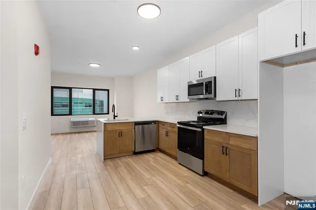 a kitchen with stainless steel appliances a stove sink and microwave