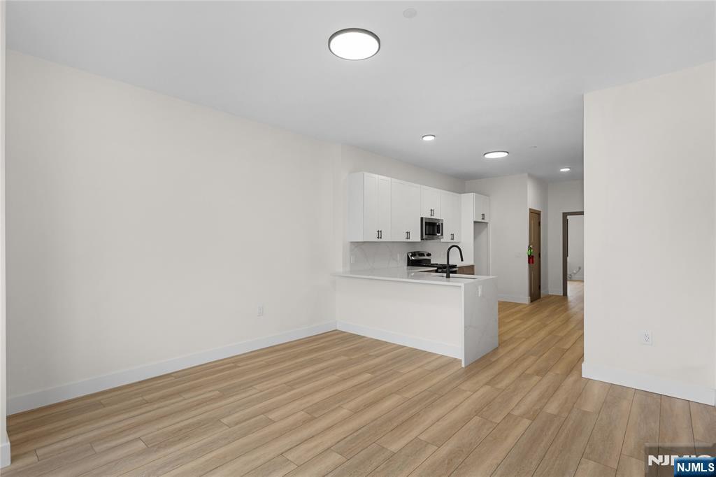 89 Mary Street, Unit 506 Paterson, NJ 07503 - Photo 7 of 15 a kitchen with a refrigerator and cabinets