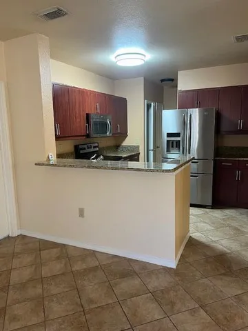 a kitchen with granite countertop a stove microwave and cabinets