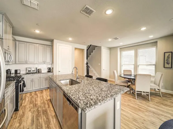 a kitchen with sink refrigerator dining table and chairs