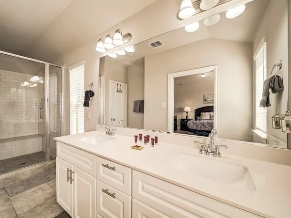 a bathroom with a sink double vanity granite and a mirror