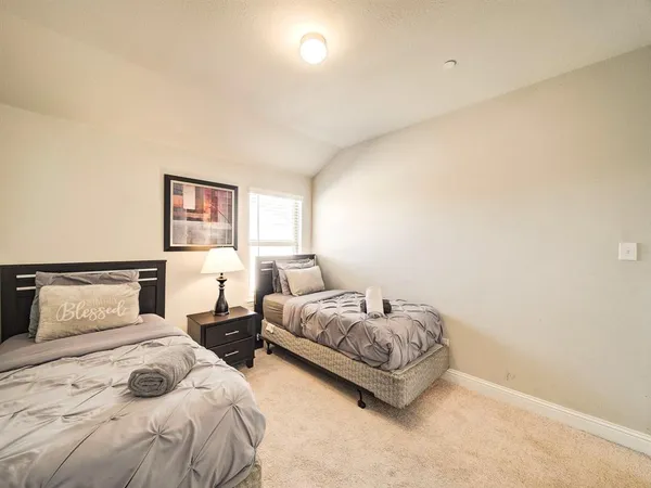 a bedroom with two beds and a night stand