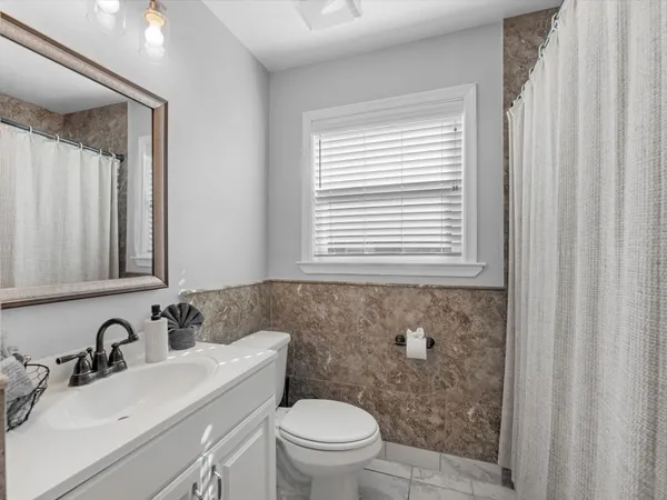 a bathroom with a sink a toilet and a mirror