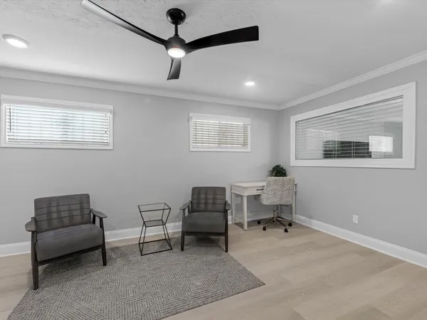 a living room with furniture and a ceiling fan