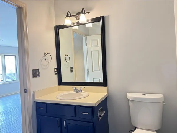 a bathroom with a toilet sink and mirror