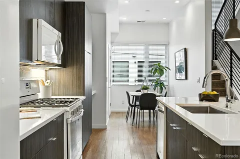 a kitchen with granite countertop a sink stove and cabinets
