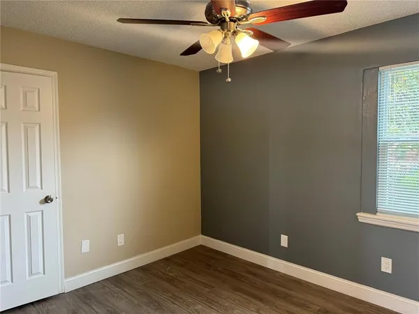 a view of an empty room with window and wooden floor