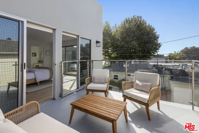 a balcony with furniture and a potted plant