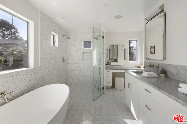 a bathroom with a granite countertop sink mirror and a bathtub