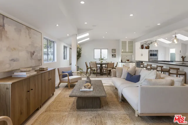 a living room with furniture and a view of kitchen