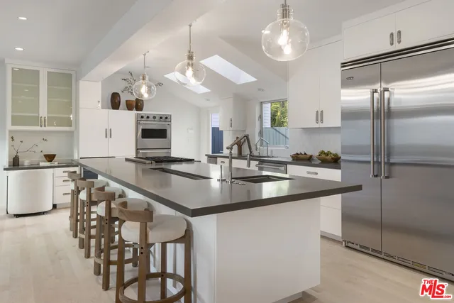 a kitchen with stainless steel appliances granite countertop a sink a stove and a refrigerator