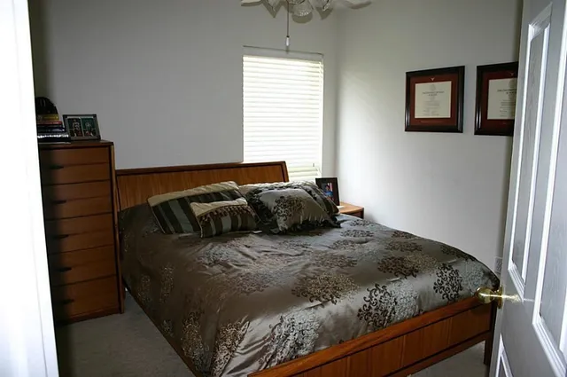 a bed sitting in a bedroom next to a window