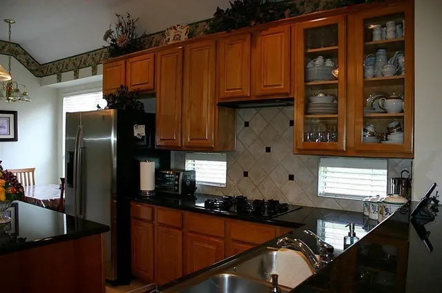 a kitchen with stainless steel appliances granite countertop a refrigerator and a sink