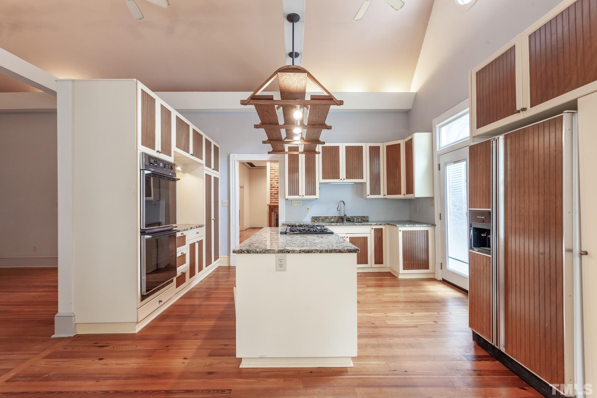 323 East Lane Street Raleigh, NC 27601 - Photo 19 of 42 a kitchen with stainless steel appliances granite countertop a refrigerator a stove microwave and a dining table with wooden floor
