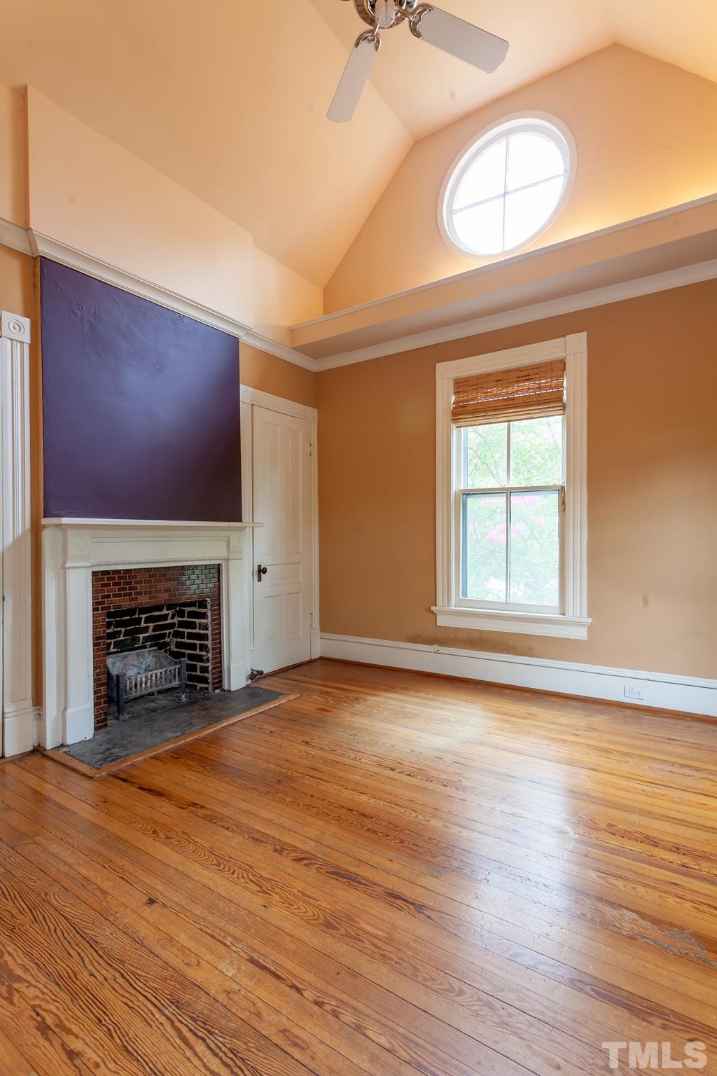 323 East Lane Street Raleigh, NC 27601 - Photo 27 of 42 an empty room with wooden floor fireplace and windows