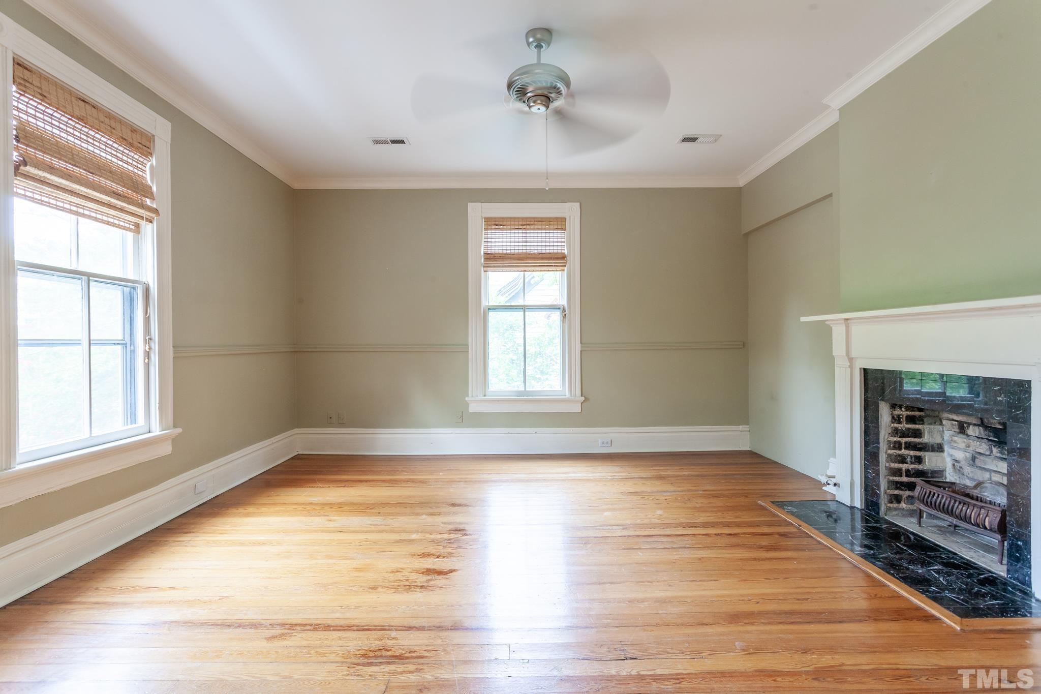 323 East Lane Street Raleigh, NC 27601 - Photo 28 of 42 a view of an empty room with wooden floor fireplace and a window